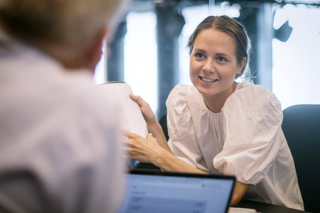 To mennesker engasjert i en samtale over et bord.